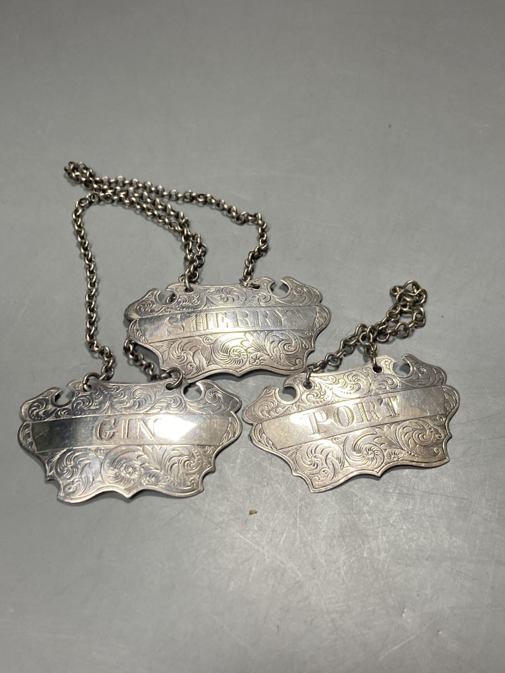 A matched set of three Victorian engraved provincial silver wine labels by William Rawlings Sobey,
